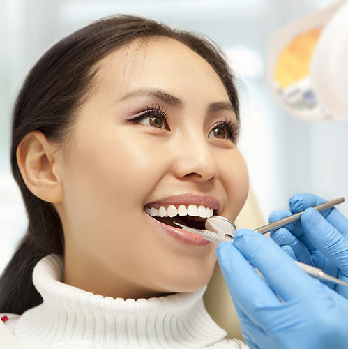woman smiling at dentist teeth cleaning
